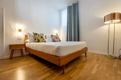 a bedroom with a bed with white sheets and a window at Vatican Vita Apartment in Rome