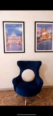 a blue chair with a white pillow in a room at Casa Arya in Rome