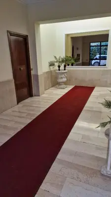 a large red carpet in a hallway with a door at Casa Arya in Rome