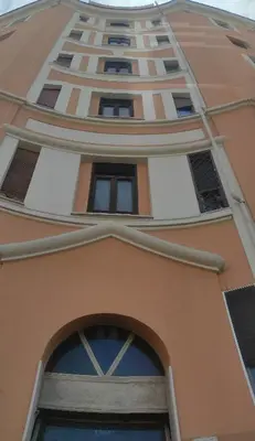 a tall orange building with an arched window at TIBERIVS Home in Rome