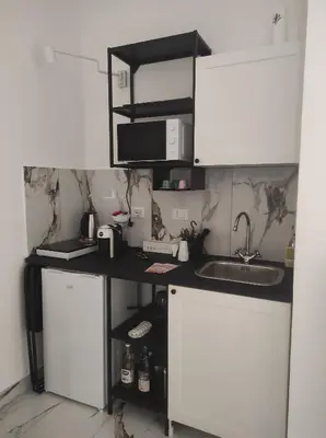 a kitchen with white cabinets and a sink at TIBERIVS Home in Rome