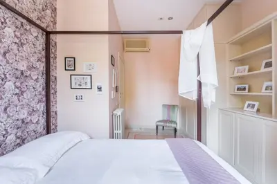 a bedroom with a white bed and a pink wall at Elizabeth Penthouse, Charmy Apartment in Little London 10 Min From the Center in Rome