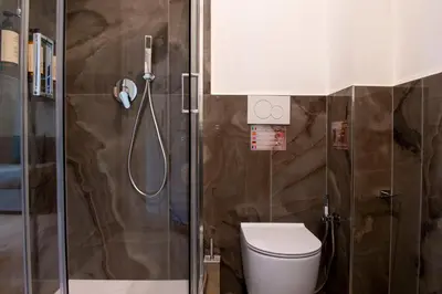 a bathroom with a toilet and a shower at Hotel AD Suites Nazionale in Rome
