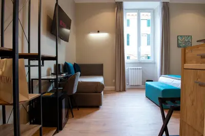 a small room with a bed and a couch at Hotel AD Suites Nazionale in Rome