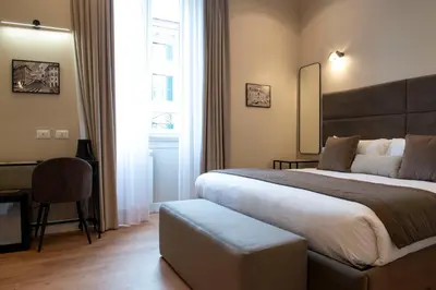 a hotel room with a large bed and a desk at Hotel AD Suites Nazionale in Rome
