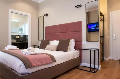 a bedroom with a large bed and a mirror at Hotel AD Suites Nazionale in Rome
