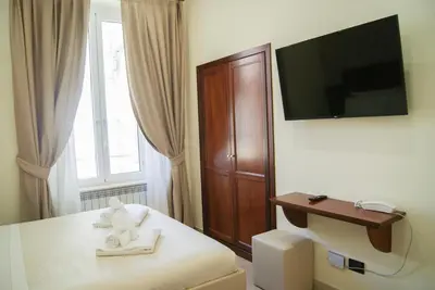 a hotel room with a bed and a tv on a wall at Glam Luxury Rome in Rome