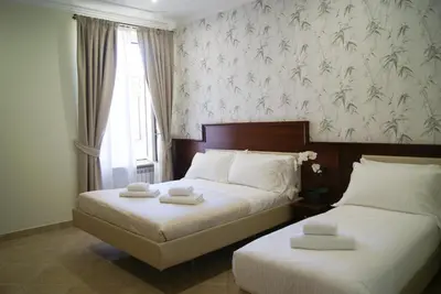 two beds in a hotel room with a window at Glam Luxury Rome in Rome