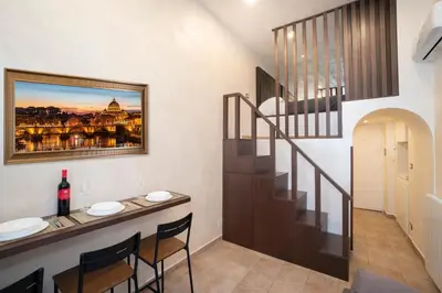a dining room with a table and a stairway at Popolo Pen 3 Apartament in Rome