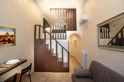 a staircase in a living room with a desk and a table at Popolo Pen 3 Apartament in Rome