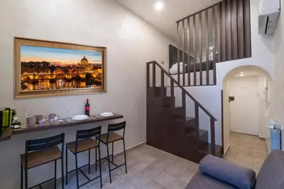 a kitchen with a bar with stools and a staircase at Popolo Pen 3 Apartament in Rome
