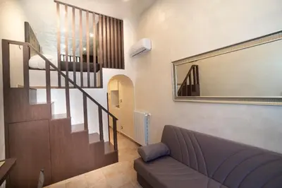 a living room with a couch and a staircase at Popolo Pen 3 Apartament in Rome