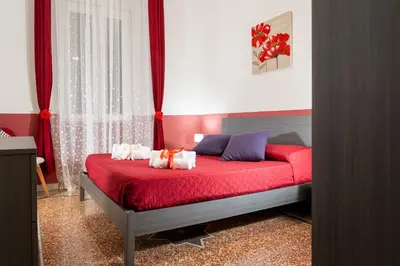 a bedroom with a red bed with towels on it at HolidayHomeNazzarena in Rome