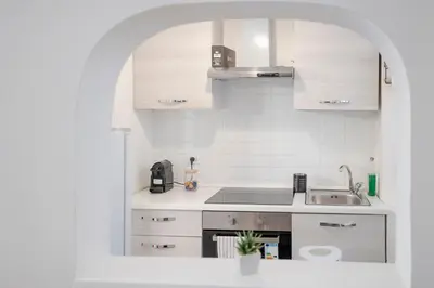 a white kitchen with a sink and a stove at Home d'Elite Trevi Fountain in Rome