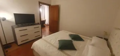 a bedroom with a white bed and a television at Home d'Elite Trevi Fountain in Rome