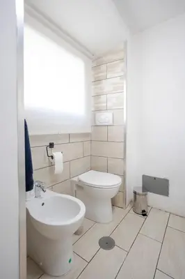a white bathroom with a toilet and a sink at Home d'Elite Trevi Fountain in Rome