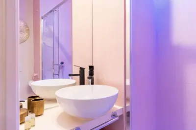 a bathroom with two white sinks and a mirror at The 62 Home l Homkeey Apartments in Rome