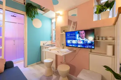 a living room with a tv on a wall at The 62 Home l Homkeey Apartments in Rome