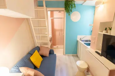 a living room with a blue couch and a kitchen at The 62 Home l Homkeey Apartments in Rome