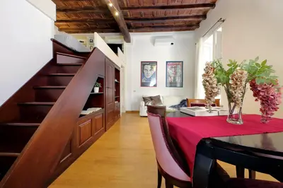 a dining room with a table and a staircase at Borgo Comfortable Loft in Rome