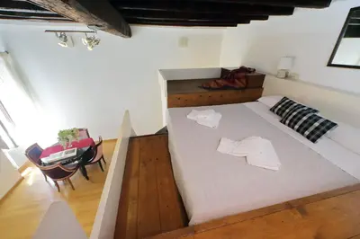 a large white bed in a room with a table at Borgo Comfortable Loft in Rome