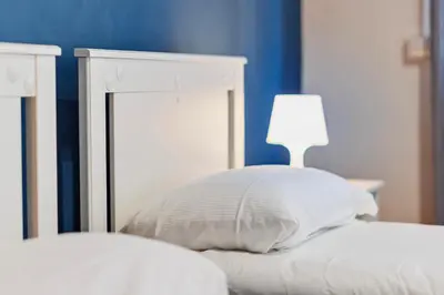 a bed with a pillow and a lamp on it at Monferrato Home in Rome