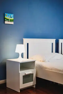 a bedroom with a white bed with a blue wall at Monferrato Home in Rome
